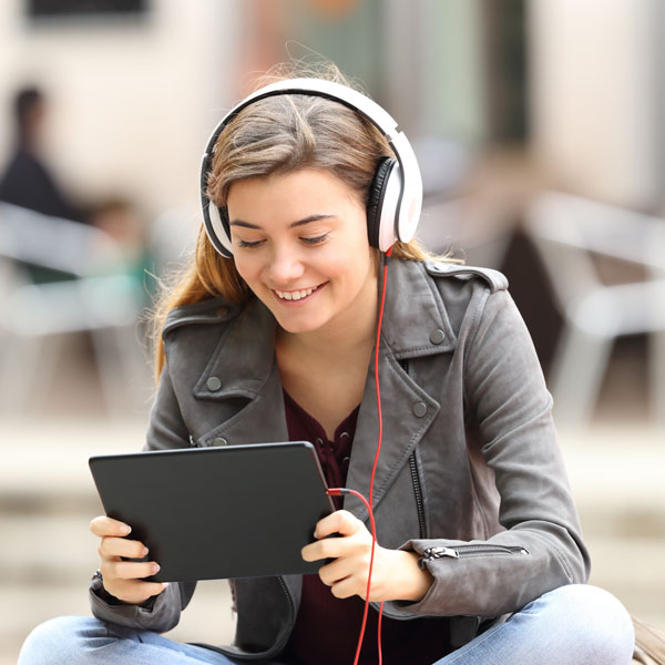 Female student listening to podcast on headphones